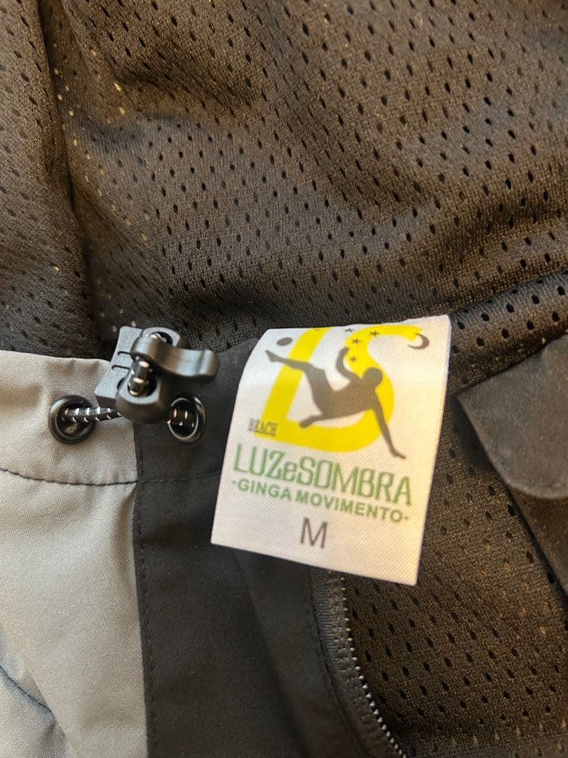Luz e Sombra Mサイズ ピステ・ウィンドブレーカー